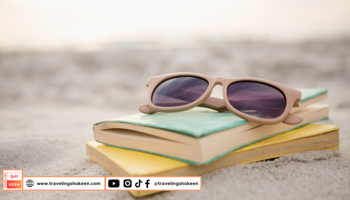 Person reading one of the best books for solo beach trips while relaxing on the sand